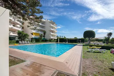 a swimming pool in front of a building at T1 em Vilamoura - Parque Mourabel in Vilamoura