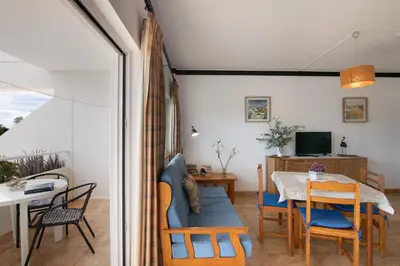 a living room with a table and a dining room at T1 em Vilamoura - Parque Mourabel in Vilamoura