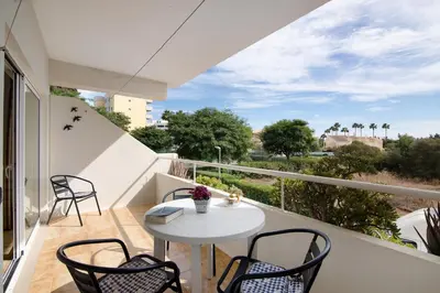 a balcony with a white table and chairs at T1 em Vilamoura - Parque Mourabel in Vilamoura