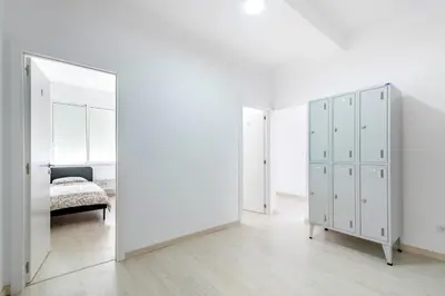a bedroom with white cabinets and a mirror at GrowIN Stay Mercado in Faro