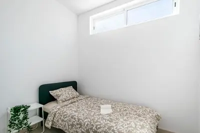 a bedroom with a bed and a window at GrowIN Stay Mercado in Faro
