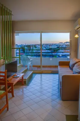 a living room with a couch and a view of a city at Ourabay Hotel Apartamento - Art & Holidays in Albufeira