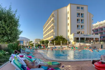 a pool at a resort with people laying on lawn chairs at Ourabay Hotel Apartamento - Art & Holidays in Albufeira