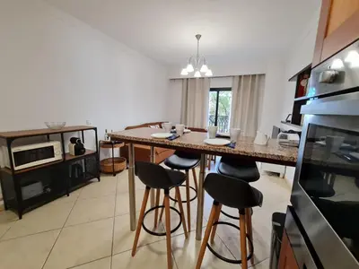 a kitchen with a table and stools in a room at Colina do Atlântico 203 in Albufeira