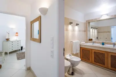 a bathroom with a sink and a toilet and a mirror at Villa Carlos in Loulé