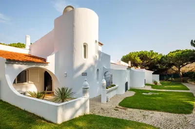 a white house with a pathway leading to a yard at Villa Carlos in Loulé