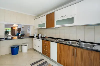 a kitchen with white cabinets and a sink in it at Villa Carlos in Loulé