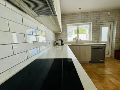 a large kitchen with a counter and a sink at Casa Da Amélia in Albufeira