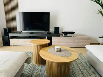 a living room with two wooden tables and a television at Casa Da Amélia in Albufeira