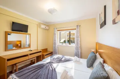 a bedroom with a bed and a mirror at Jardins Vale de Parra in Albufeira