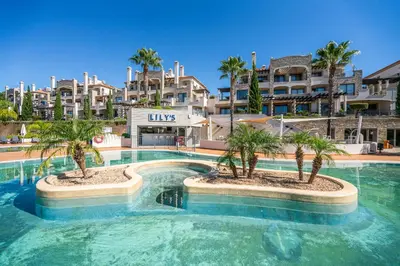 a swimming pool with palm trees in a resort at Vilamoura Pine Hills with Pool by Homing in Vilamoura