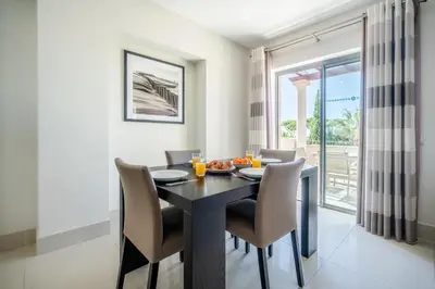 a dining room with a black table and chairs at Vilamoura Pine Hills with Pool by Homing in Vilamoura