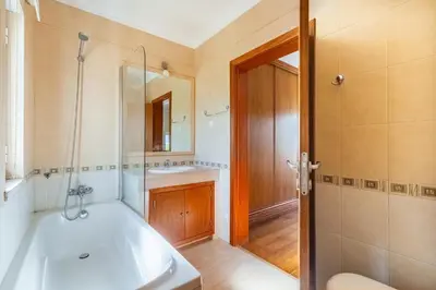 a bathroom with a tub and a sink and a mirror at Villa Coute Real in Quarteira