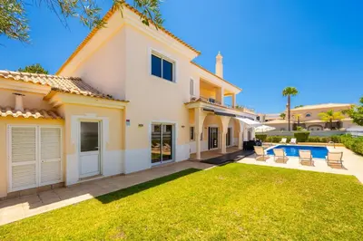 a house with a pool and a yard at Villa Coute Real in Quarteira
