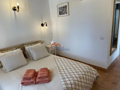 a bedroom with a bed with two towels on it at Monte Gerações - Complete House - Heated pool - Typical Algarvian - close to Quinta Lago Vale Lobo and Vilamoura in Almancil