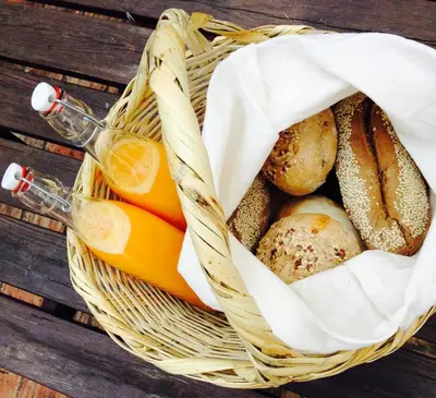 a basket of bread and a bottle of orange juice at Casas Adentro in Faro