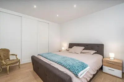 a bedroom with a large bed and a chair at Casa da Amélia in Albufeira