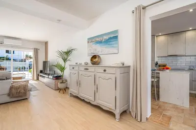 a kitchen and a living room with a table at Casa da Amélia in Albufeira