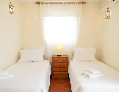 two twin beds in a room with a window at Villa Lydika I in Albufeira