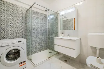 a bedroom with a bed with a dresser and a mirror at Blue Wave Apartment in Albufeira