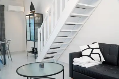 a living room with a black couch and a glass table at Apartamento Bernard in Albufeira