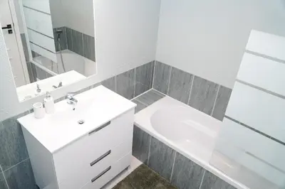 a white bathroom with a sink and a tub at Apartamento Bernard in Albufeira