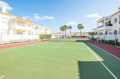 a tennis court in front of some apartment buildings at Apartamento Bernard in Albufeira