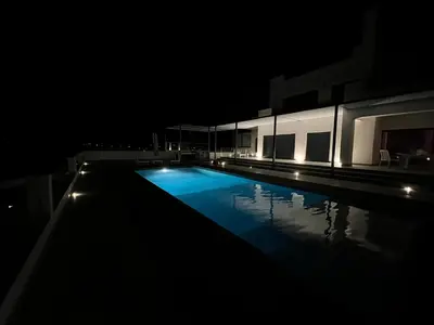 an empty swimming pool at night with lights at villagoldra rentals - Luxury and Family Villa in Goldra de Baixo