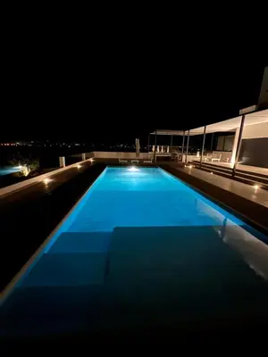 a swimming pool on the roof of a building at night at villagoldra rentals - Luxury and Family Villa in Goldra de Baixo
