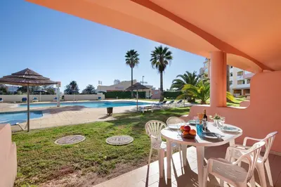a patio with a table and chairs and a pool at Bela Vista House T2 in Albufeira