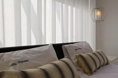 a bedroom with a bed with two pillows and a window at Villa Pinheiro CD 84 - Cleverdetails in Vilamoura
