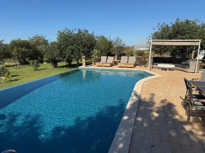 a swimming pool with chairs and a gazebo at Casa Tranquility with beautiful heated pool and Jacuzzi! in Loulé