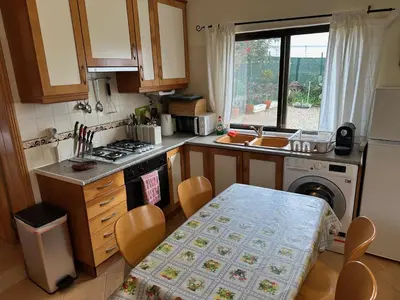 a small kitchen with a table and a stove at Casa Tranquility with beautiful heated pool and Jacuzzi! in Loulé