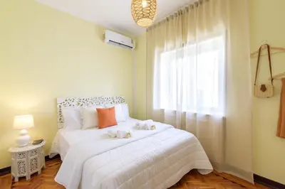 a bedroom with a white bed with two stuffed animals on it at Urban Bliss Guesthouse II in Faro
