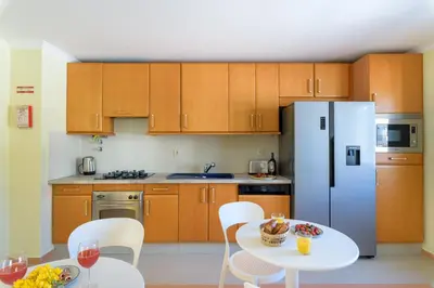 a kitchen with a white table and a refrigerator at Urban Bliss Guesthouse II in Faro