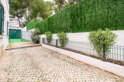 a fence with plants on it next to a sidewalk at Urban Bliss Guesthouse II in Faro