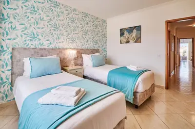two beds in a room with blue and white walls at Apartment O Monte mit Pool in Guia