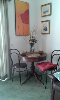 a dining room table with chairs and a vase with flowers at Villa Quica, heated pool in Albufeira