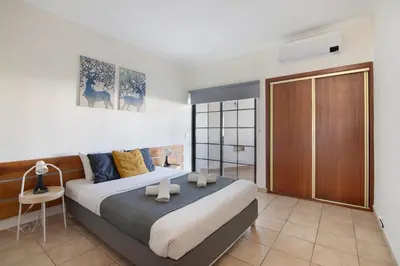 a bedroom with a large bed with a wooden door at Apartamento Sousa e Filhos in Albufeira