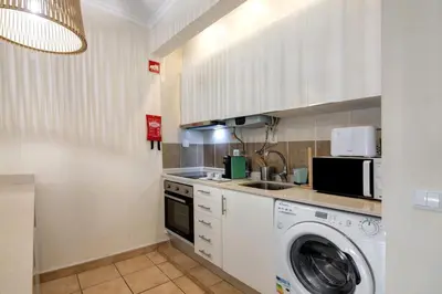 a kitchen with a washing machine and a washer at Apartamento Sousa e Filhos in Albufeira