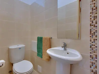 a bathroom with a white toilet and a sink at Inn The Beach Apartments by Seareen in Albufeira