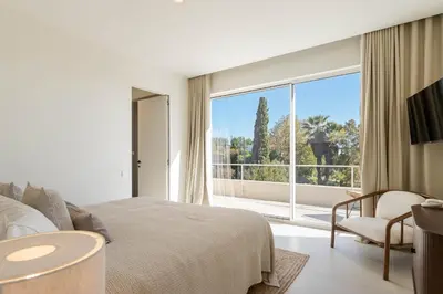 a bedroom with a bed and a large window at Modern Sea View Villa, Heated Pool,Rooftop Jacuzzi Outdoor Kitchen 12min faro Airport in Santa Bárbara de Nexe