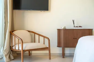 a chair sitting in a room next to a dresser at Modern Sea View Villa, Heated Pool,Rooftop Jacuzzi Outdoor Kitchen 12min faro Airport in Santa Bárbara de Nexe