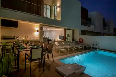 a dining room with a long table and chairs at Villa MariVital I Luxury I Heated Pool I Old Town in Albufeira
