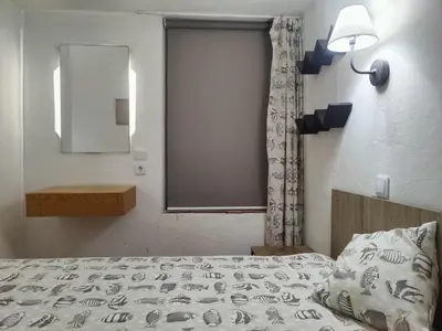 a bedroom with a bed and a mirror and a window at Casa do Cedro in Albufeira