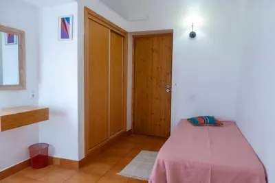 a room with a bed and a wooden door at Casa do Cedro in Albufeira