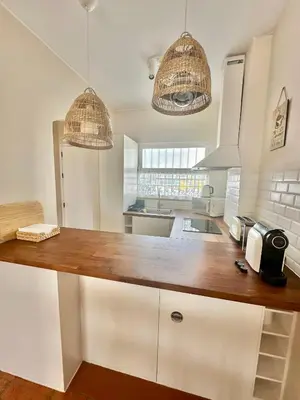 a kitchen with white cabinets and wooden counter top at Solar Home appartement T2 in Albufeira
