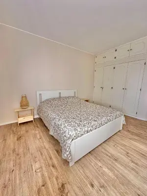 a bedroom with a bed and a wooden floor at Solar Home appartement T2 in Albufeira