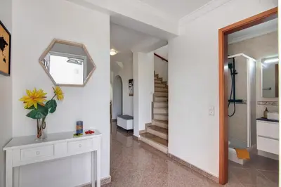 a hallway with white walls and a mirror and stairs at Villa Martina in Albufeira