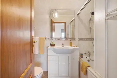 a hallway with white walls and a staircase with a bench at Villa Martina in Albufeira